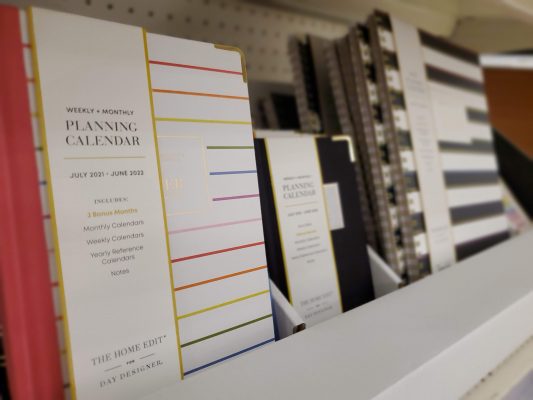 Various sized planners with stripes on the covers.