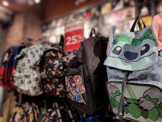 Rack of backpacks including a backpack of Stitch.